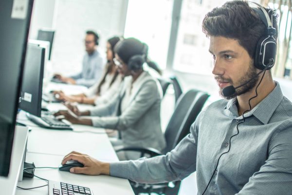 Handsome young male customer support executive working in office. Handsome young male customer support executive working in office.